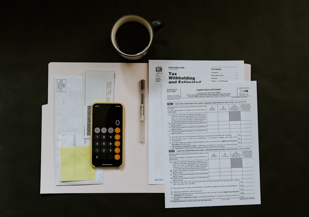 black-android-smartphone-near-ballpoint-pen-tax-withholding-certificate-on-top-of-white-folder-m98nrbuzbpc